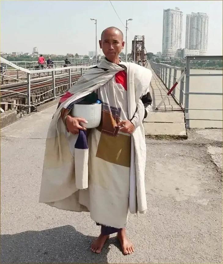 A person wearing a robe and holding a white object
Description automatically generated