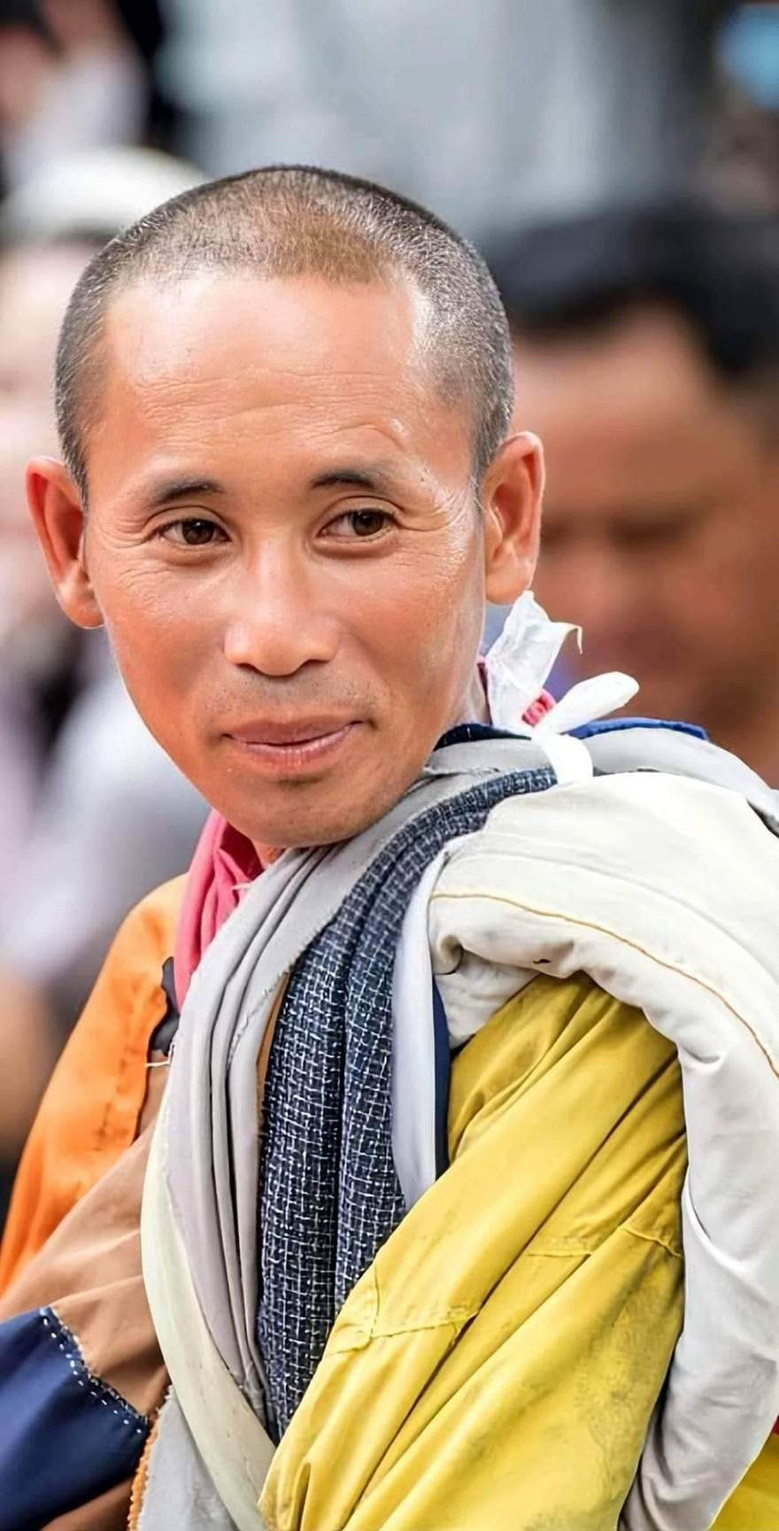 A person with a scarf around his neck
Description automatically generated